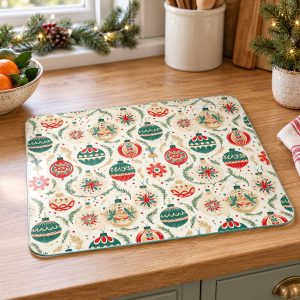 Tuftop Christmas Vintage Bauble glass worktop protector on an oak kitchen worktop beside festive greenery in daylight